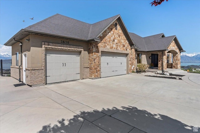 3630 S Panorama Dr W, Saratoga Springs, UT 84045 - view of front of property with a mountain view, an attached garage, concrete driveway, and stone siding