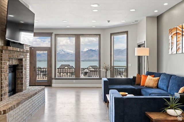 3630 S Panorama Dr W, Saratoga Springs, UT 84045 - living room featuring a fireplace, recessed lighting, baseboards, wood finished floors, and a water view