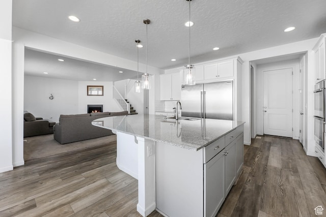 728 W Wild Hyacinth Dr, Saratoga Springs, UT 84045 - kitchen featuring open floor plan, recessed lighting, white cabinetry, a sink, and appliances with stainless steel finishes