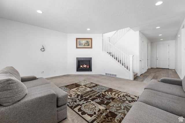 728 W Wild Hyacinth Dr, Saratoga Springs, UT 84045 - living room featuring visible vents, a glass covered fireplace, baseboards, recessed lighting, and carpet