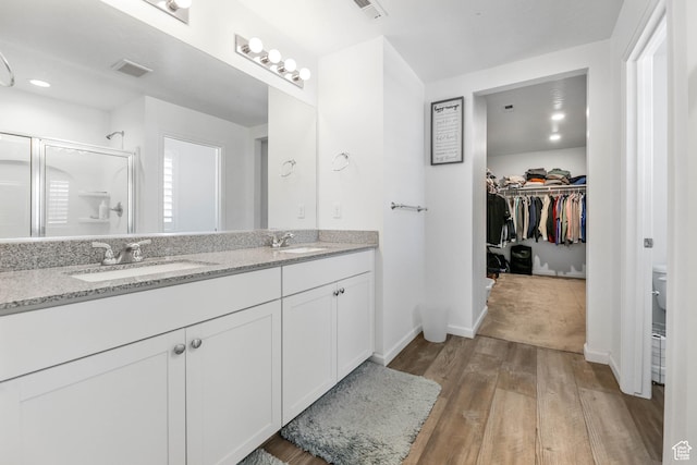 728 W Wild Hyacinth Dr, Saratoga Springs, UT 84045 - bathroom with visible vents, a sink, wood finished floors, and a stall shower