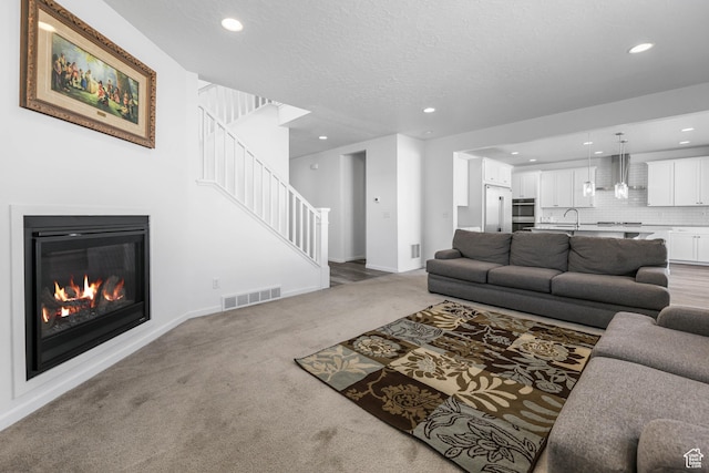 728 W Wild Hyacinth Dr, Saratoga Springs, UT 84045 - living room featuring visible vents, stairs, light carpet, baseboards, and recessed lighting