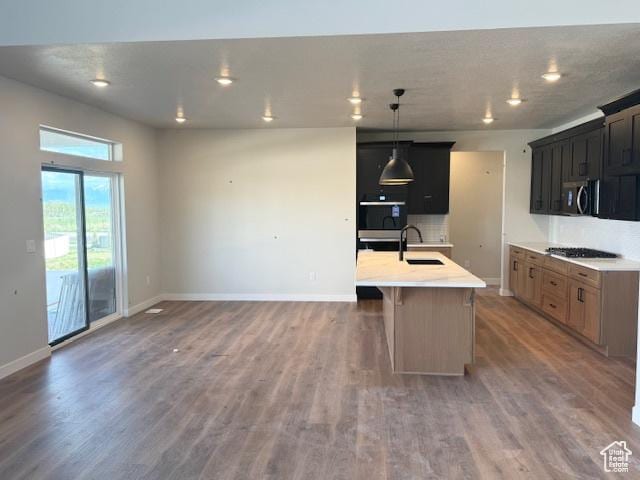 166 N Husker Ln Unit 1, Saratoga Springs, UT 84045 - kitchen with stainless steel microwave, a sink, gas stovetop, light wood finished floors, and light countertops