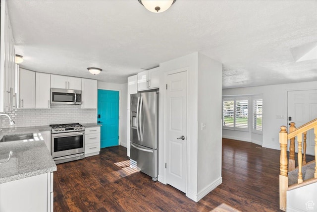 12455 S 1450 W, Riverton, UT 84065 - kitchen featuring baseboards, dark wood-type flooring, white cabinets, a sink, and stainless steel appliances