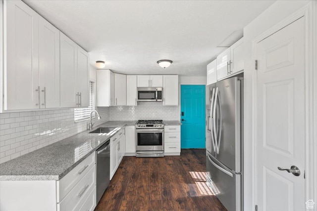 12455 S 1450 W, Riverton, UT 84065 - kitchen with white cabinets, tasteful backsplash, a sink, dark wood finished floors, and appliances with stainless steel finishes