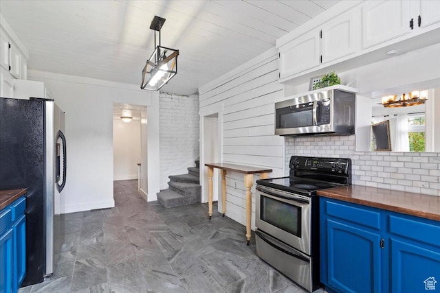 95 N 200 W, Brigham City, UT 84302 - kitchen featuring decorative backsplash, butcher block countertops, white cabinetry, blue cabinets, and appliances with stainless steel finishes