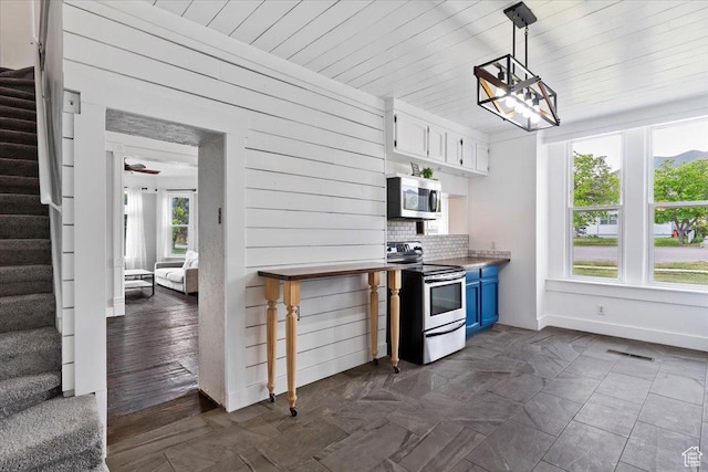 95 N 200 W, Brigham City, UT 84302 - kitchen featuring white cabinets, appliances with stainless steel finishes, blue cabinetry, decorative light fixtures, and visible vents