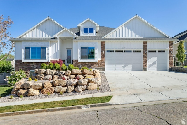 view of front of property featuring board and batten siding, roof with shingles, a garage, concrete driveway, and stone siding