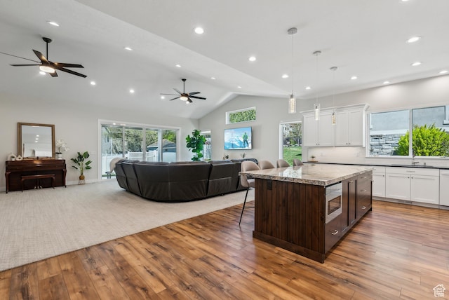 735 E 850 S, Centerville, UT 84014 - kitchen featuring a ceiling fan, open floor plan, white cabinetry, vaulted ceiling, and stainless steel microwave
