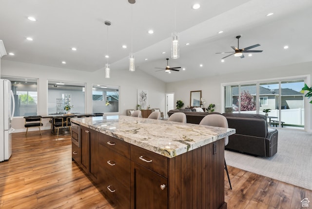 735 E 850 S, Centerville, UT 84014 - kitchen with a ceiling fan, vaulted ceiling, wood finished floors, a breakfast bar area, and freestanding refrigerator