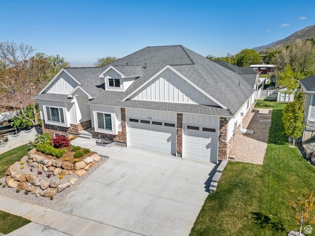 735 E 850 S, Centerville, UT 84014 - view of front of home with stone siding, roof with shingles, board and batten siding, a garage, and driveway
