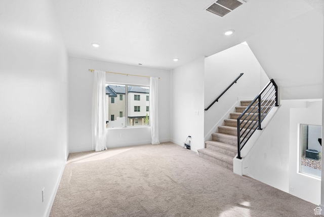 unfurnished living room featuring carpet floors, recessed lighting, and visible vents