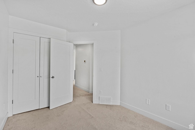 unfurnished bedroom with visible vents, carpet, baseboards, and a closet