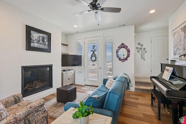 10983 S Lake Run Rd, South Jordan, UT 84009 - living area with wood finished floors, a glass covered fireplace, ceiling fan, recessed lighting, and baseboards