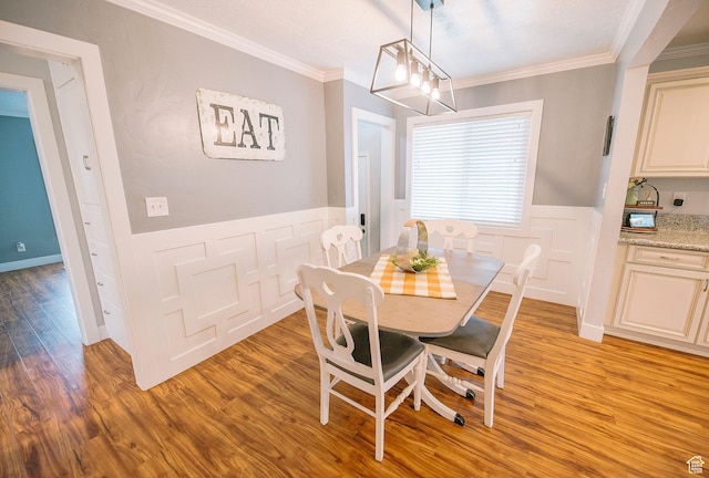 663 W 3500 S, Bountiful, UT 84010 - dining area featuring a wainscoted wall, ornamental molding, a decorative wall, and light wood-type flooring