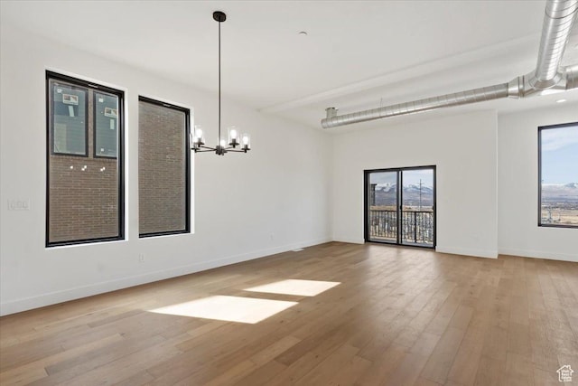 14374 S Champ Cv Unit 138, Draper, UT 84020 - unfurnished dining area featuring baseboards, an inviting chandelier, a healthy amount of sunlight, and wood finished floors