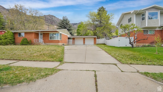 940 S Taylor E, Ogden, UT 84404 - view of front of home with fence, a front yard, brick siding, a gate, and a mountain view