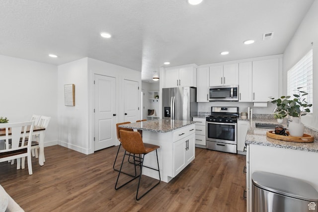 4236 N Magnolia Cir, Eagle Mountain, UT 84005 - kitchen featuring a kitchen island, stainless steel appliances, dark wood-style floors, and a kitchen breakfast bar