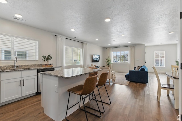 4236 N Magnolia Cir, Eagle Mountain, UT 84005 - kitchen with a breakfast bar, a sink, dark wood finished floors, open floor plan, and stainless steel dishwasher