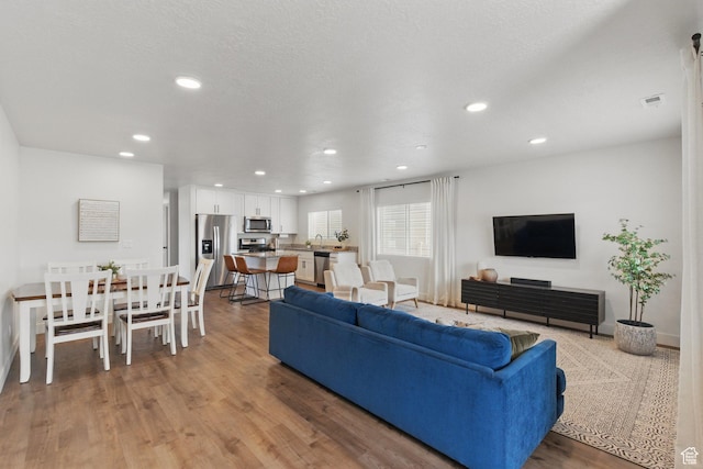 4236 N Magnolia Cir, Eagle Mountain, UT 84005 - living room with baseboards, recessed lighting, light wood-style flooring, and visible vents