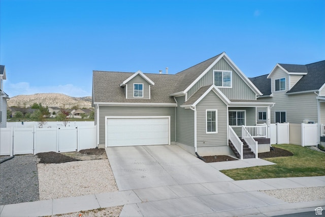 4236 N Magnolia Cir, Eagle Mountain, UT 84005 - view of front of property with fence, roof with shingles, board and batten siding, a mountain view, and concrete driveway