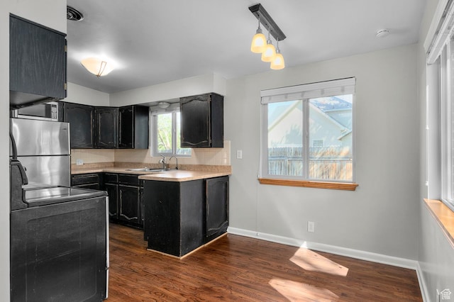 931 E 7800 S, Midvale, UT 84047 - kitchen with decorative backsplash, appliances with stainless steel finishes, a sink, dark wood-style floors, and dark cabinetry