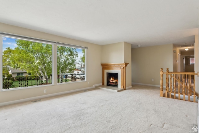 3475 S 3650 E, Millcreek, UT 84109 - unfurnished living room featuring a warm lit fireplace, baseboards, visible vents, and carpet