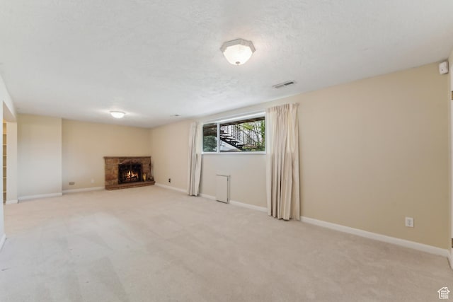 3475 S 3650 E, Millcreek, UT 84109 - unfurnished living room featuring light carpet, a warm lit fireplace, a textured ceiling, and visible vents