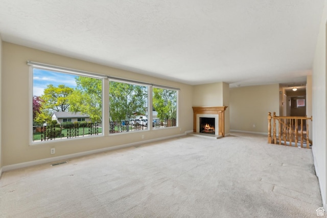3475 S 3650 E, Millcreek, UT 84109 - unfurnished living room with carpet floors, baseboards, a lit fireplace, and visible vents