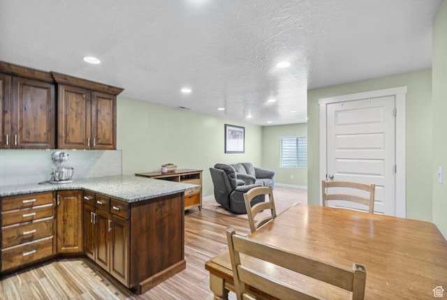 145 W 750 S, American Fork, UT 84003 - kitchen featuring decorative backsplash, light stone countertops, a peninsula, light wood-style floors, and recessed lighting