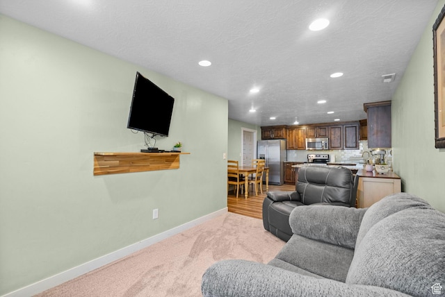 145 W 750 S, American Fork, UT 84003 - living room with recessed lighting, a textured ceiling, baseboards, and light carpet