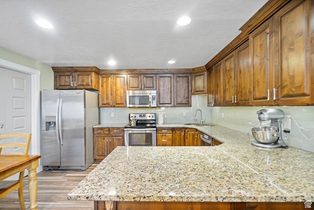 145 W 750 S, American Fork, UT 84003 - kitchen with backsplash, a sink, light stone counters, stainless steel appliances, and light wood-style flooring