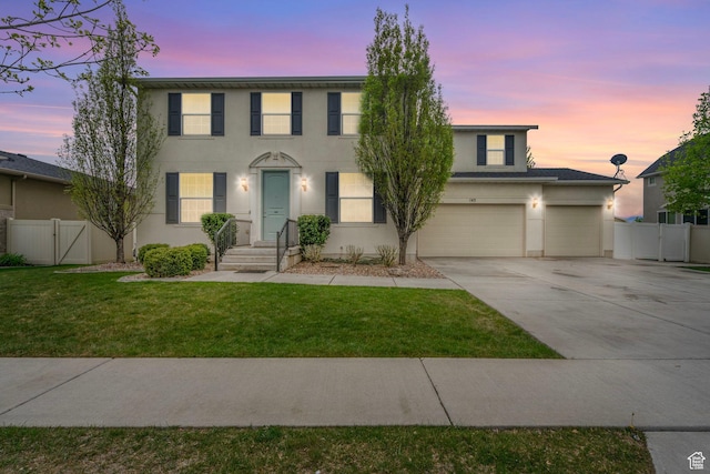 145 W 750 S, American Fork, UT 84003 - colonial house featuring concrete driveway, fence, a gate, and stucco siding
