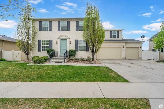 145 W 750 S, American Fork, UT 84003 - colonial home with a front lawn, fence, stucco siding, a gate, and concrete driveway