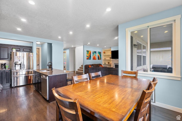 145 W 750 S, American Fork, UT 84003 - dining space featuring a fireplace, stairway, recessed lighting, a textured ceiling, and dark wood finished floors