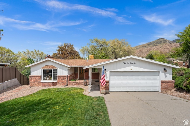 single story home featuring driveway, a front yard, a garage, brick siding, and fence