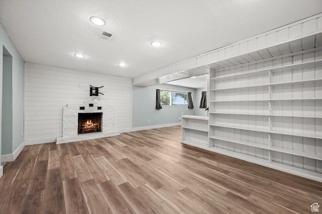 3581 E Yosemite Dr S, Millcreek, UT 84109 - unfurnished living room featuring baseboards, wood finished floors, a lit fireplace, and recessed lighting