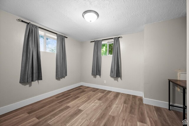 3581 E Yosemite Dr S, Millcreek, UT 84109 - empty room with a textured ceiling, wood finished floors, and baseboards