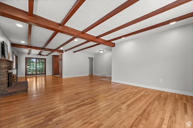 3581 E Yosemite Dr S, Millcreek, UT 84109 - unfurnished living room featuring light wood-style floors, beam ceiling, ceiling fan, a stone fireplace, and recessed lighting