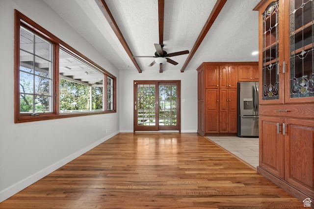 3581 E Yosemite Dr S, Millcreek, UT 84109 - unfurnished living room with beamed ceiling, light wood-style floors, ceiling fan, baseboards, and a textured ceiling