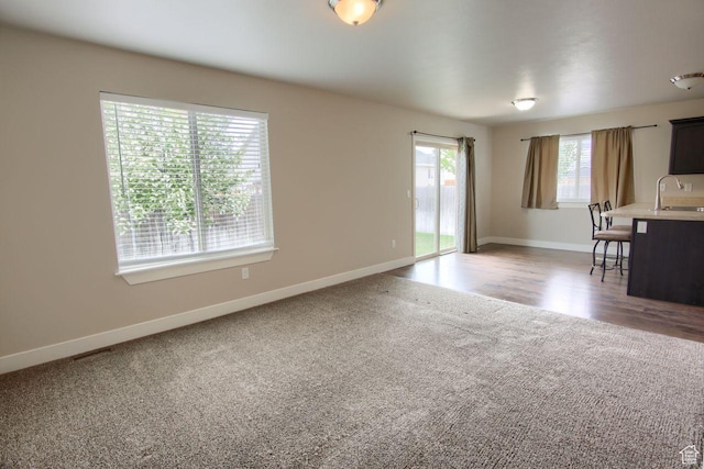 566 N 640 W, Tooele, UT 84074 - unfurnished living room featuring a sink, baseboards, and light colored carpet