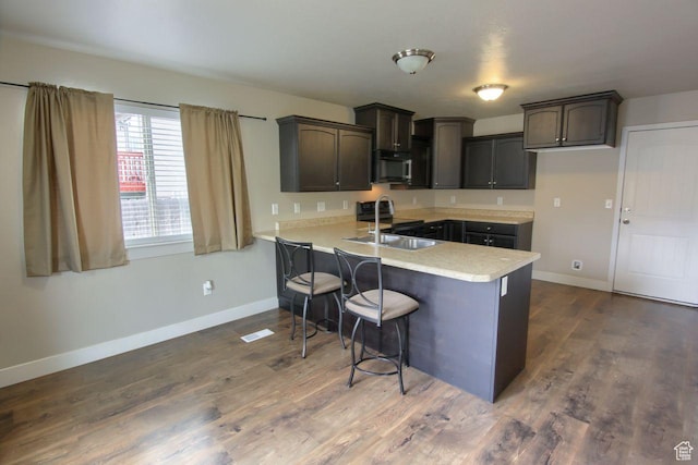 566 N 640 W, Tooele, UT 84074 - kitchen with a sink, light countertops, a breakfast bar area, a peninsula, and baseboards