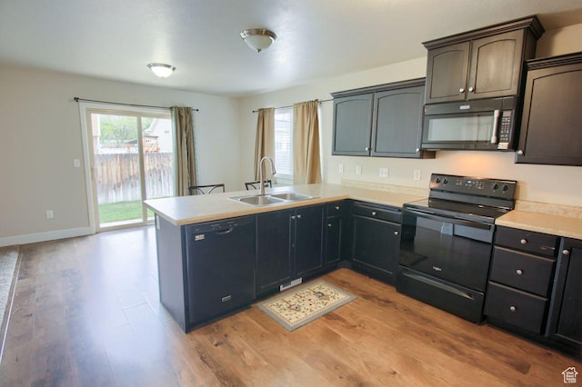 566 N 640 W, Tooele, UT 84074 - kitchen featuring a sink, light wood-style floors, light countertops, a peninsula, and black appliances