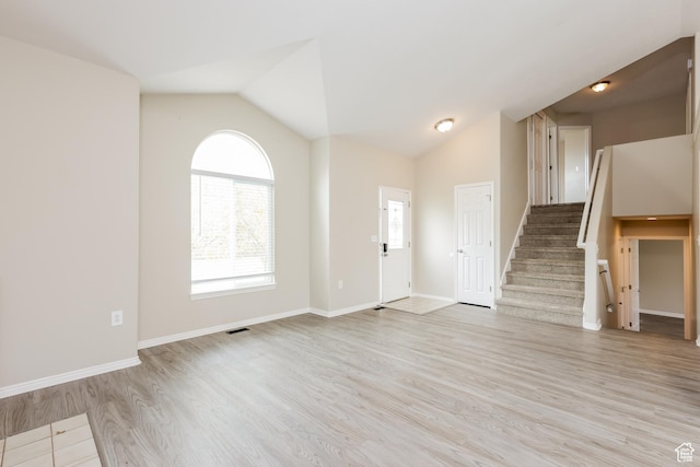 4018 W 5250 S, Roy, UT 84067 - unfurnished living room featuring visible vents, baseboards, stairway, light wood-style flooring, and vaulted ceiling