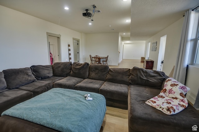 living area with recessed lighting, light wood finished floors, and visible vents