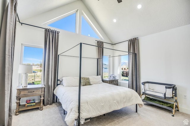 bedroom featuring carpet floors, high vaulted ceiling, and multiple windows