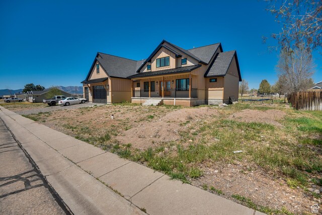 craftsman inspired home with fence, covered porch, a standing seam roof, metal roof, and an attached garage