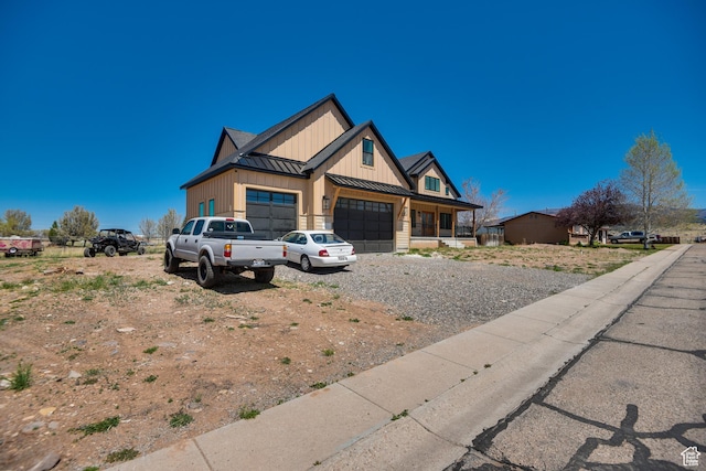 view of front facade featuring board and batten siding, a standing seam roof, metal roof, dirt driveway, and an attached garage