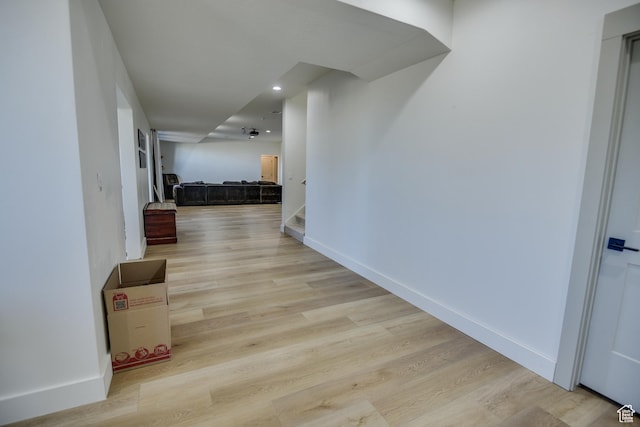 hallway featuring light wood-style floors, recessed lighting, baseboards, and stairway