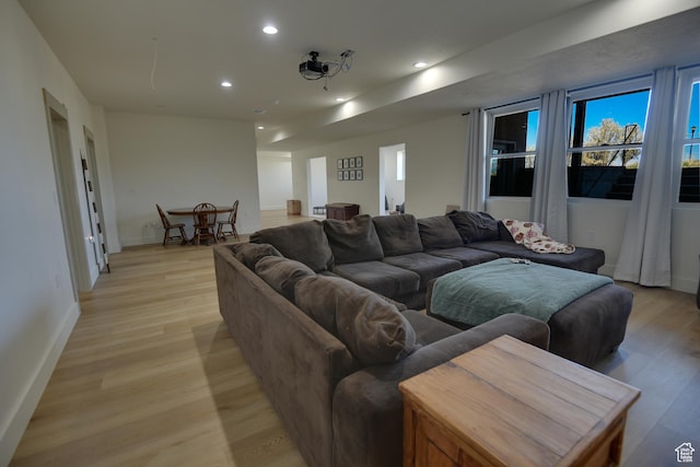 living room featuring recessed lighting, baseboards, and light wood finished floors